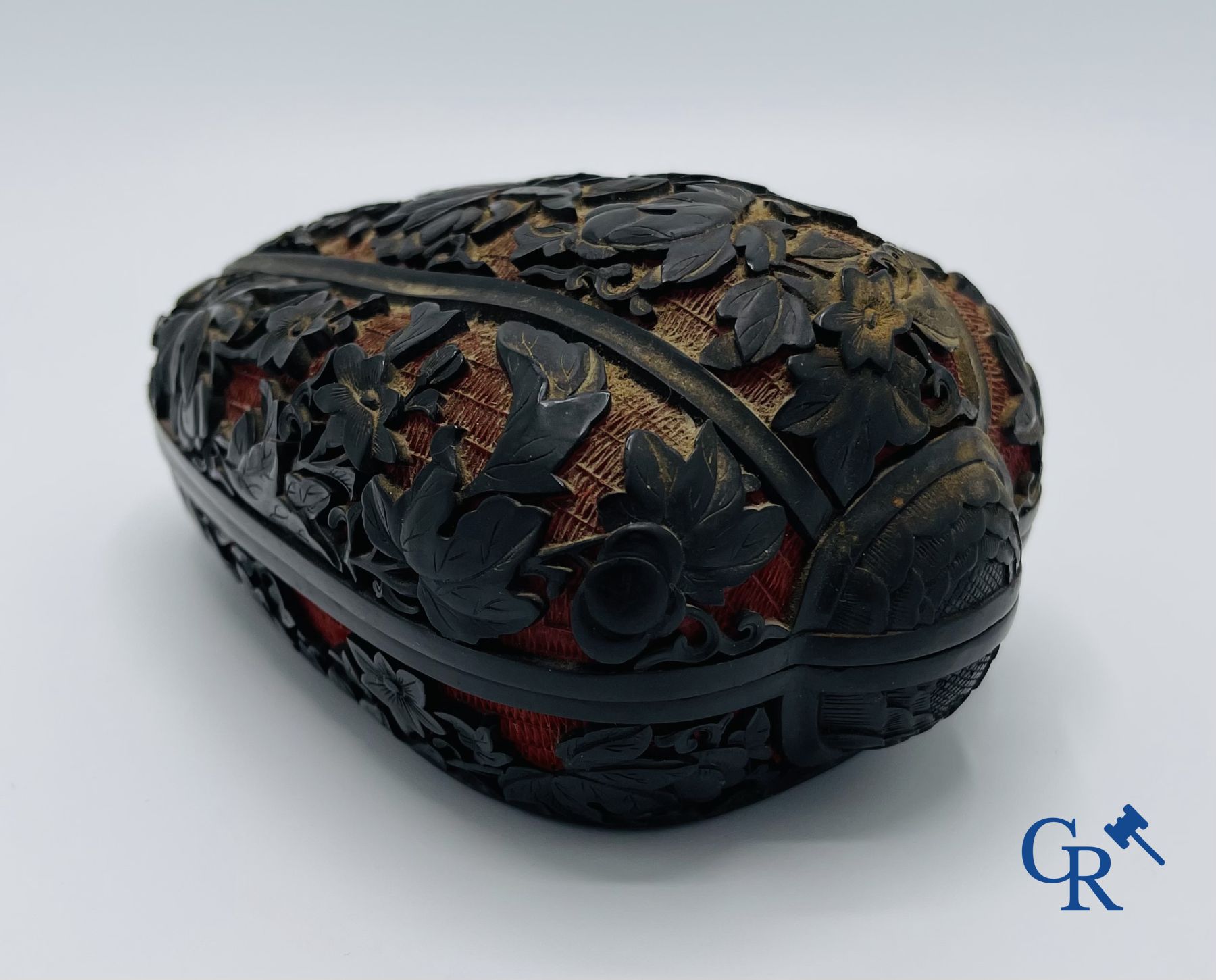 Asian Art: A finely carved Chinese lid box in black lacquer on a red background.