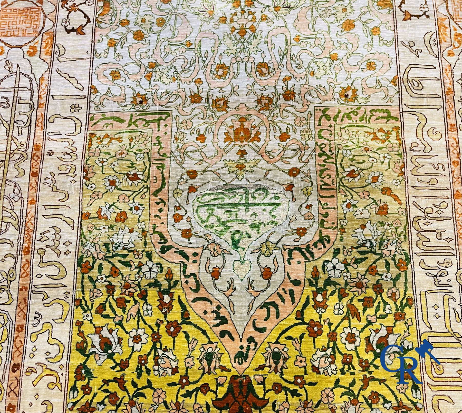 Oosterse tapijten: Een uitzonderlijk gesigneerd tapijt in zijde en gouddraad met verzen en een floraal decor.