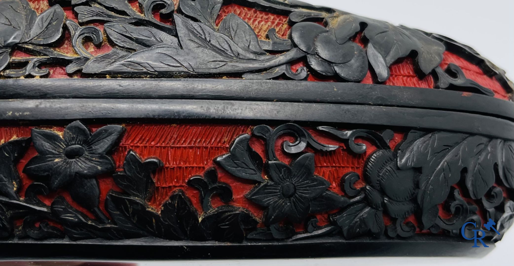 Asian Art: A finely carved Chinese lid box in black lacquer on a red background.