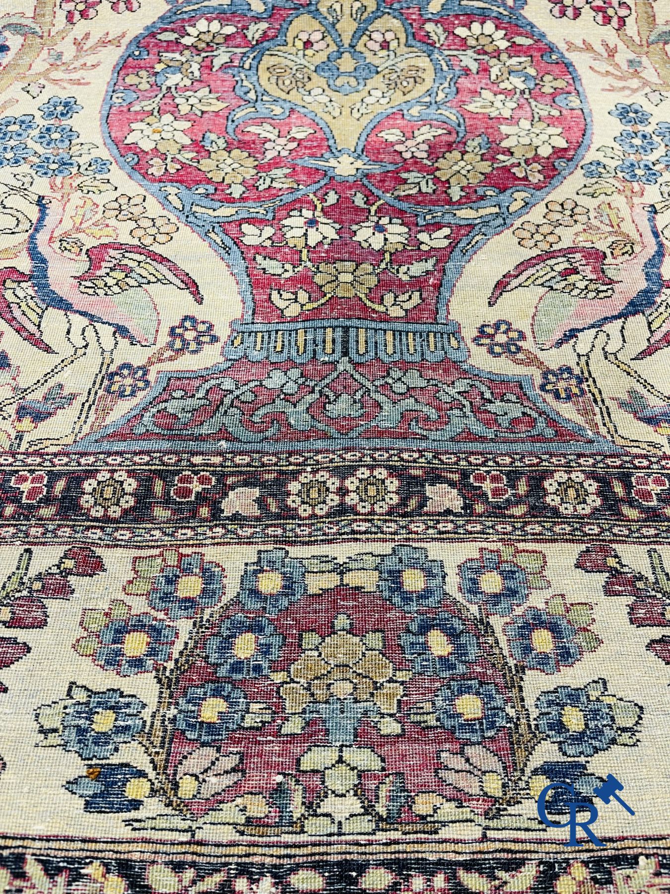 Oosterse tapijten. Iran. Perzisch tapijt met een bloemenvaas, vogels en konijnen in een floraal decor.