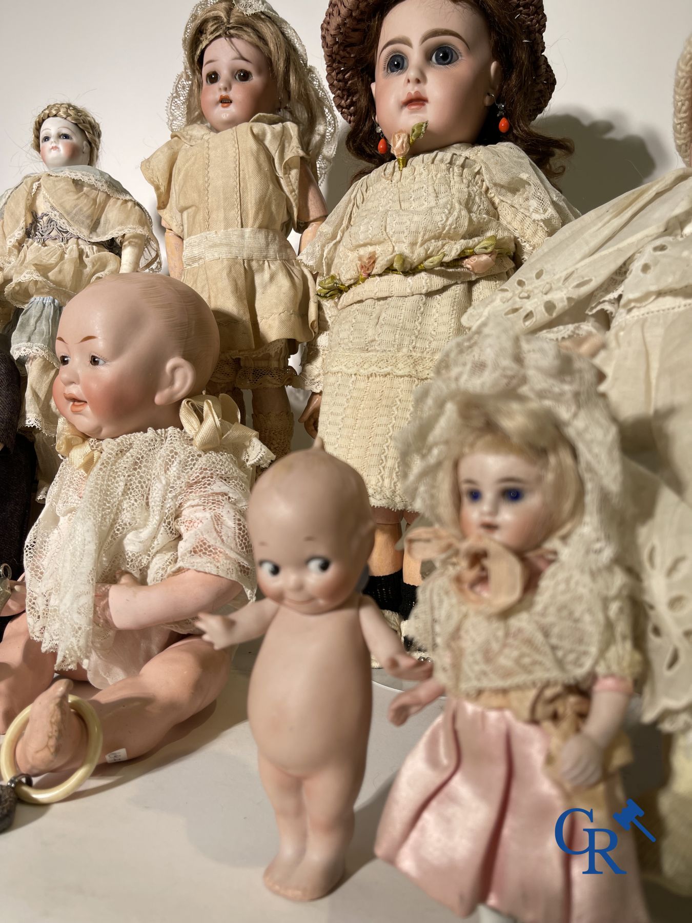 Speelgoed: antieke poppen: Mooi lot van diverse porseleinen poppen en vitrineobjecten in zilver.