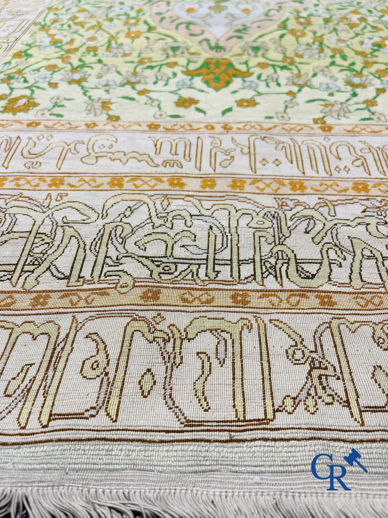 Oosterse tapijten: Een uitzonderlijk gesigneerd tapijt in zijde en gouddraad met verzen en een floraal decor.