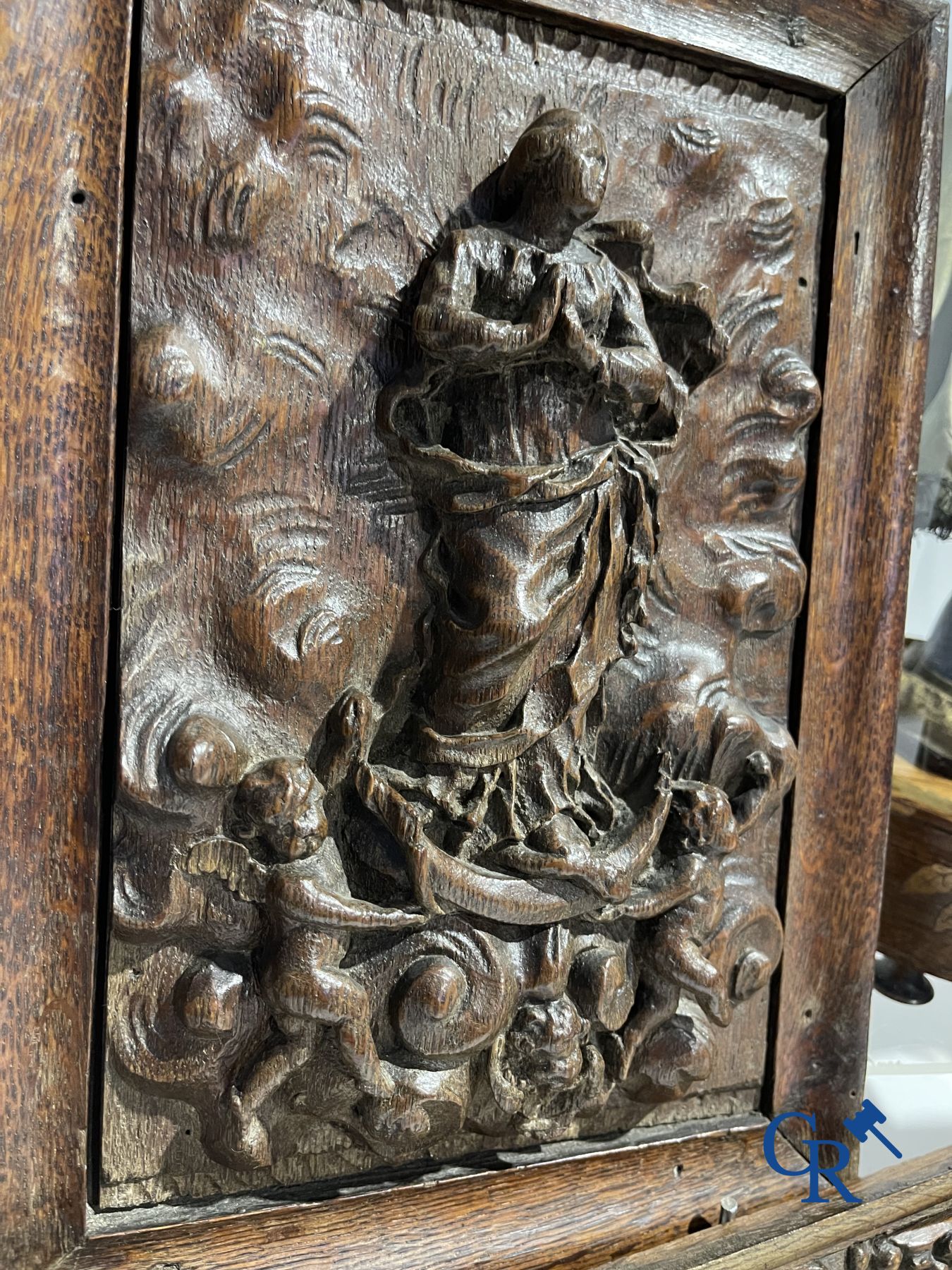 Een kavel met diverse antieke houtsculpturen en een antiek boek op lezenaar.