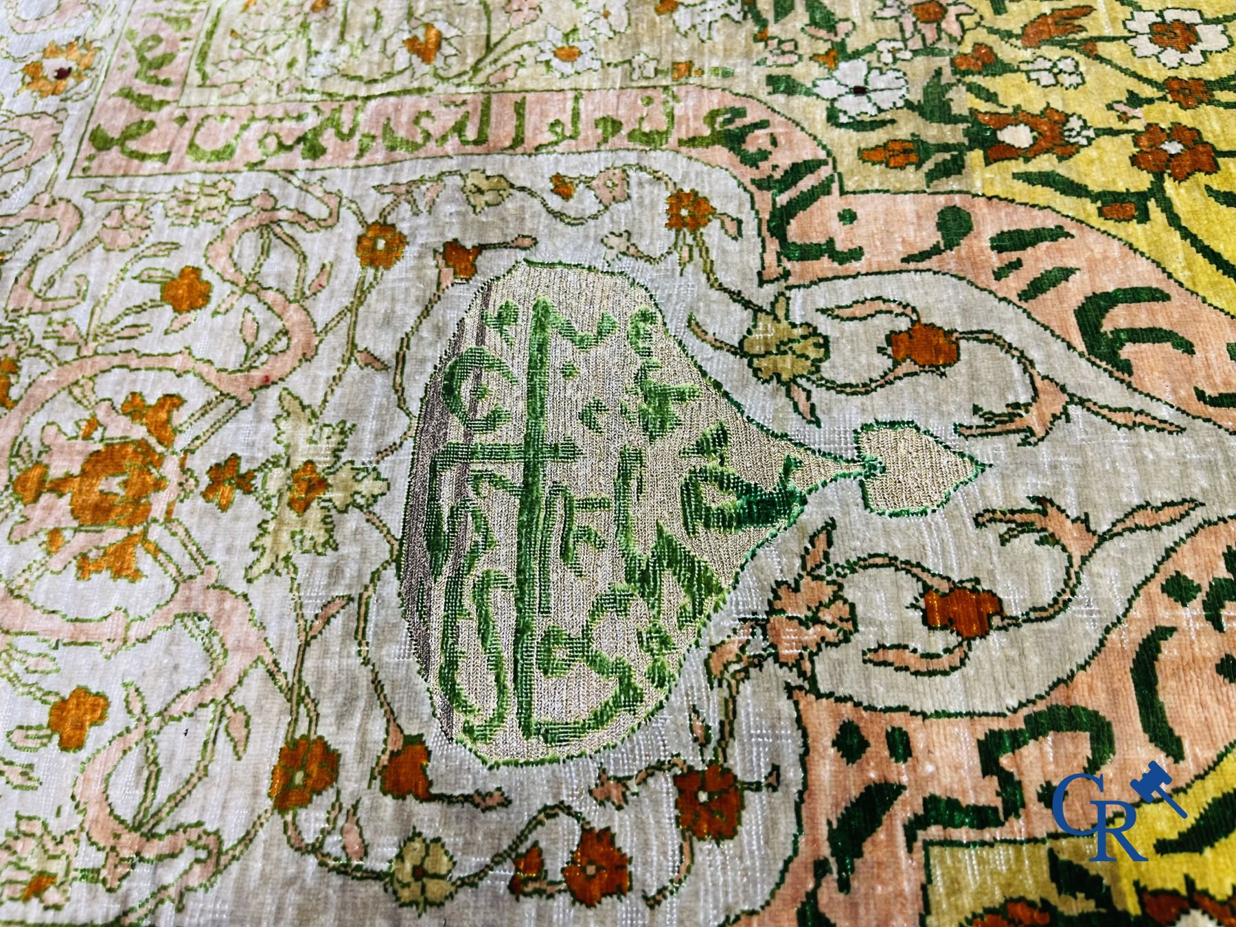 Oosterse tapijten: Een uitzonderlijk gesigneerd tapijt in zijde en gouddraad met verzen en een floraal decor.