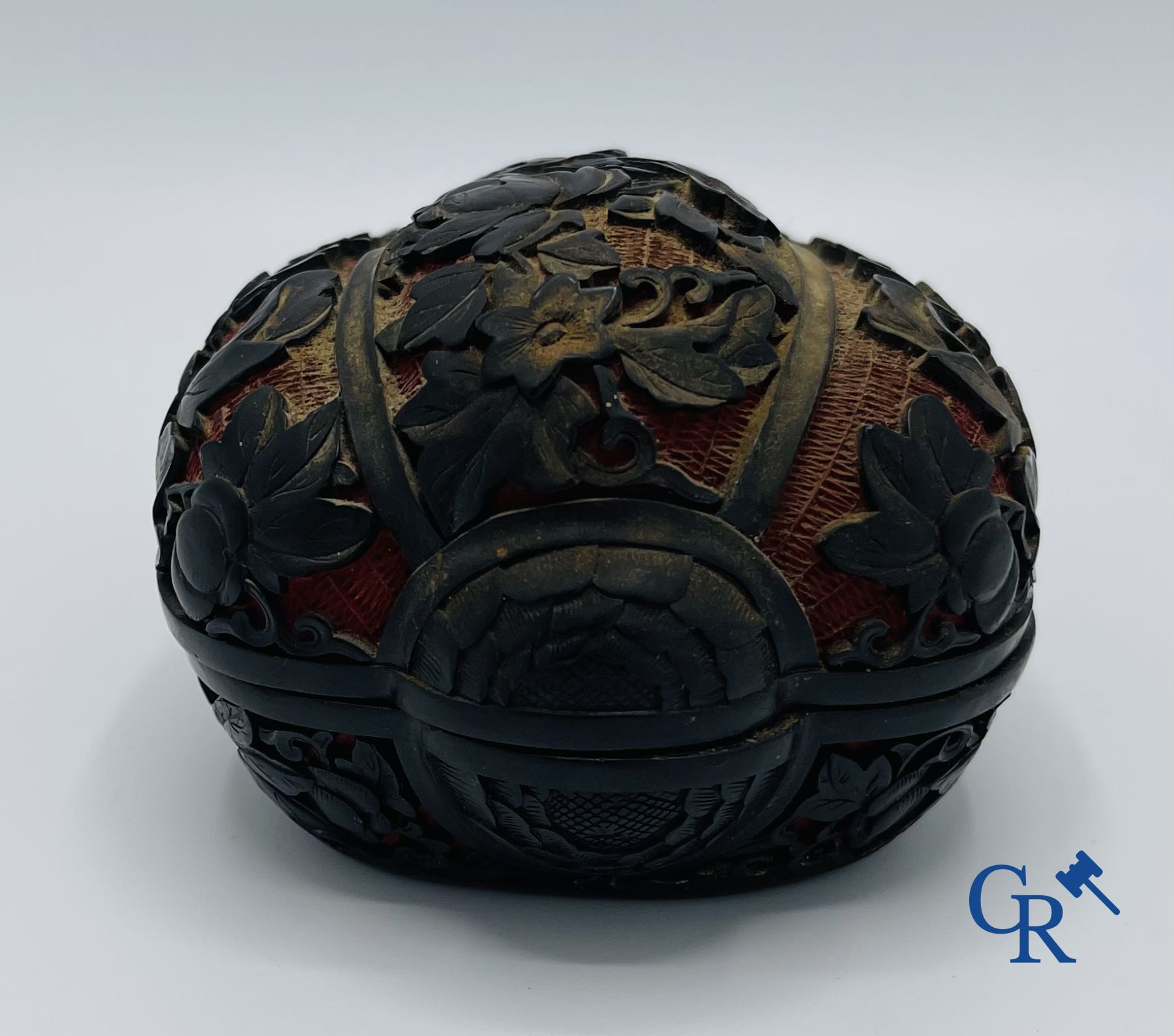 Asian Art: A finely carved Chinese lid box in black lacquer on a red background.